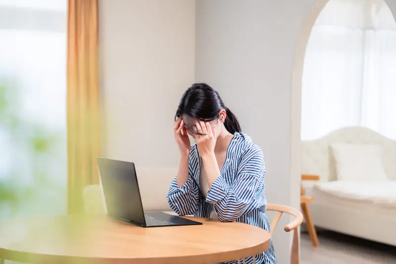 Person tippt am Laptop mit eingeblendeten digitalen Support-Elementen.